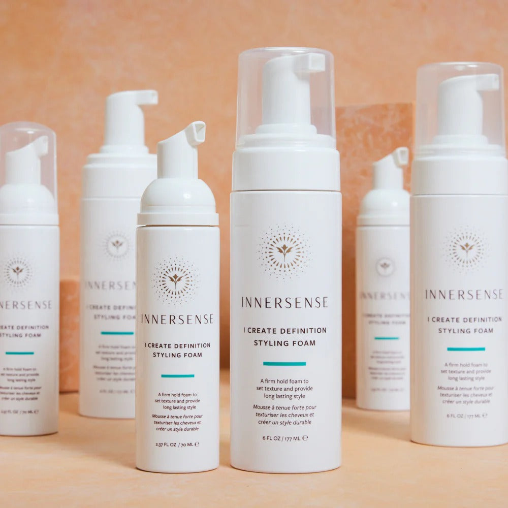 White Innersense I Create Definition Styling Foam bottles with clear pumps, varying sizes, on a light background.