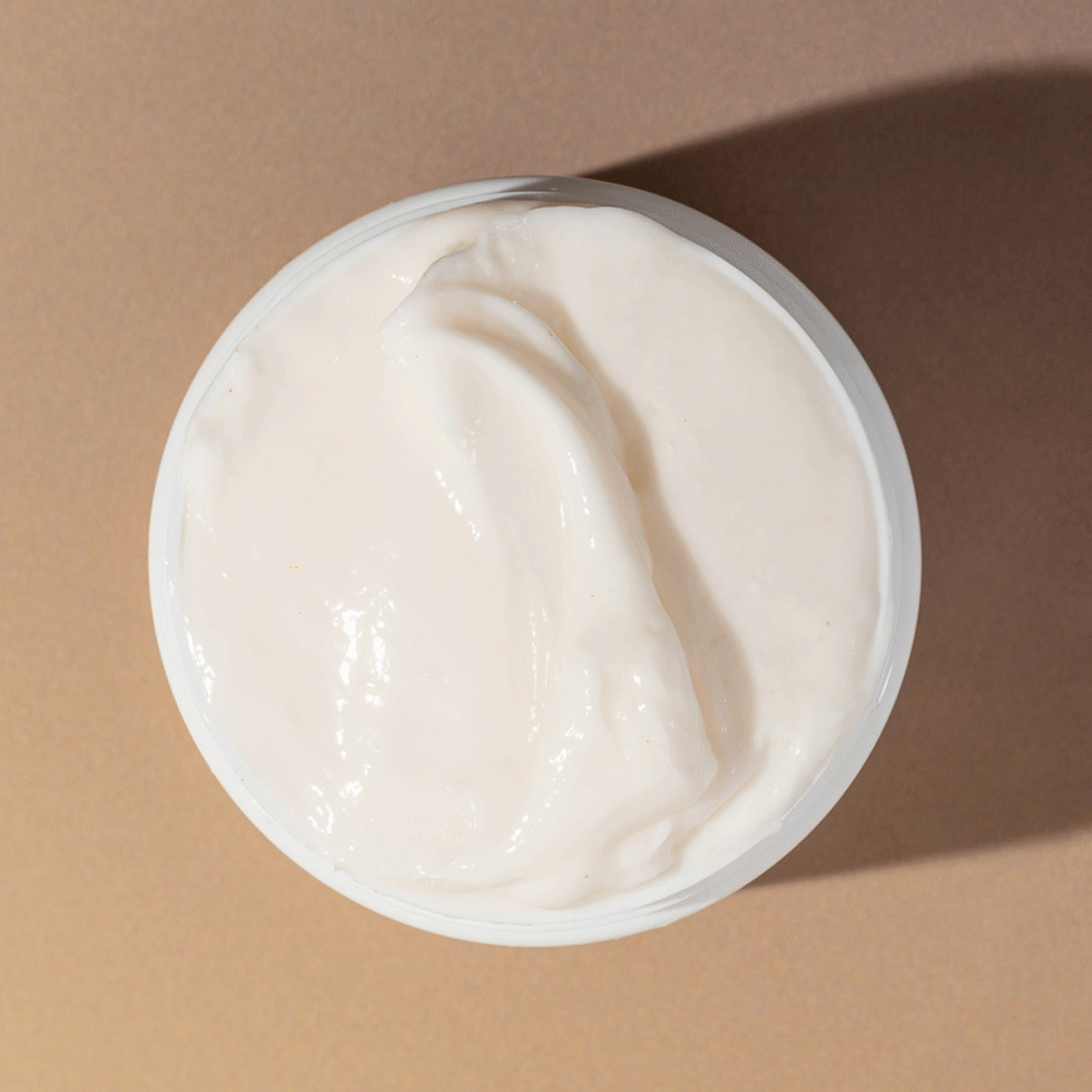 Open white jar of Bounce Curl Avocado & Rose Oil Clump & Define Cream with creamy, light beige product visible.