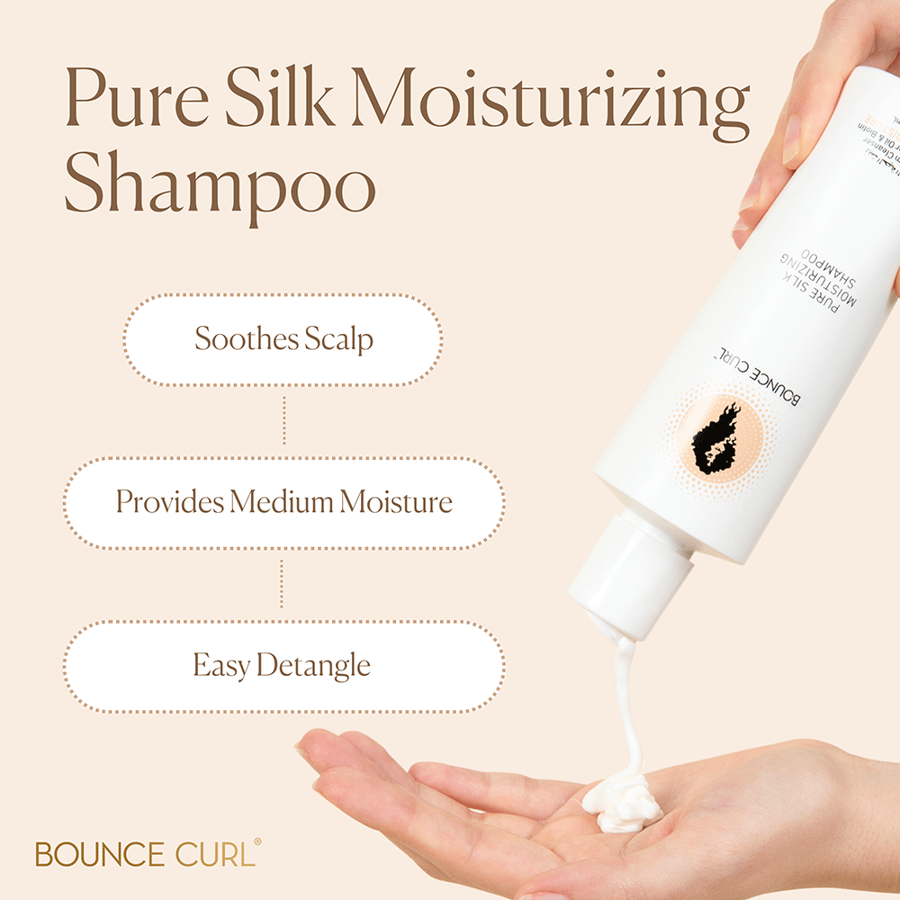 Hand squeezing white Bounce Curl Pure Silk Moisturizing Shampoo from a white bottle onto a palm.