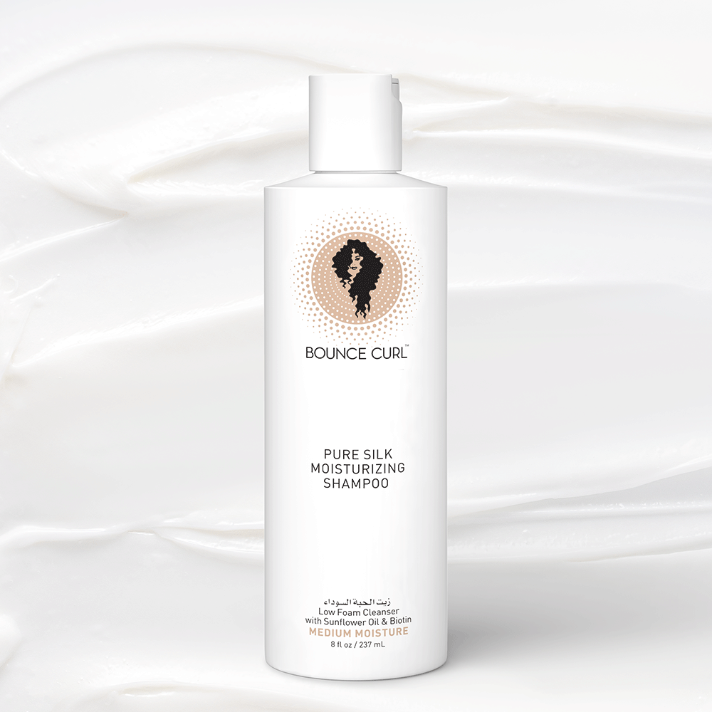 White Bounce Curl Pure Silk Moisturizing Shampoo bottle, 237ml, with a curly hair logo on a creamy background.