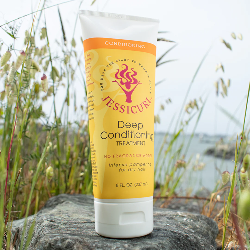 Jessicurl Deep Conditioning Treatment, an 8 fl oz yellow and white tube, on a rock outdoors.