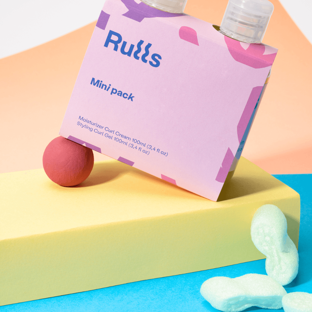 Rulls Gel+Cream Mini Pack, a pink box with blue and purple accents, on yellow and blue blocks.