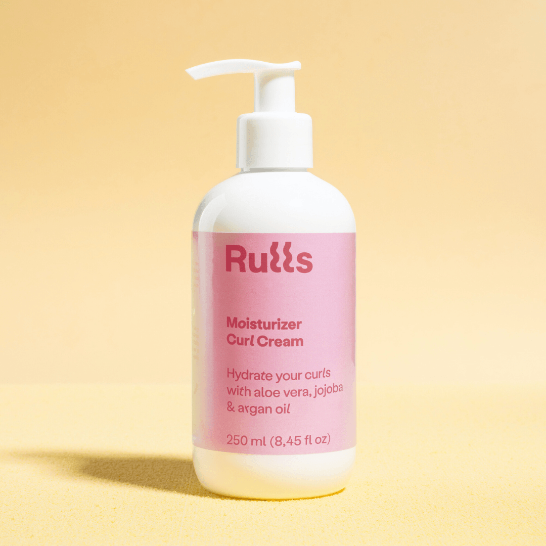 White Rulls Moisturizer Curl Cream pump bottle with pink label on a yellow background.