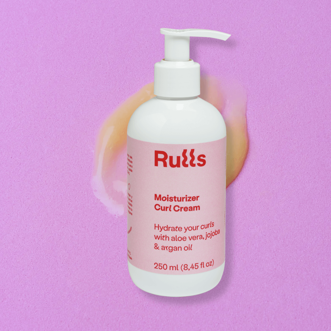 White Rulls Moisturizer Curl Cream pump bottle on a pink background with a swirl of cream.